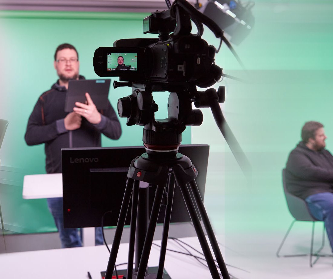 Kamera mit Stativ vor der grünen Wand im Film-Studio