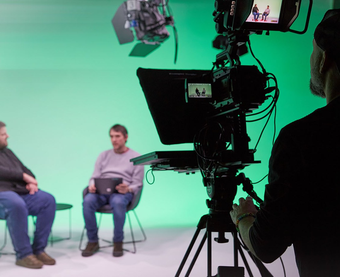 Interview vor dem Green Screen, im Vordergrund die Studiokamera mit Teleprompter